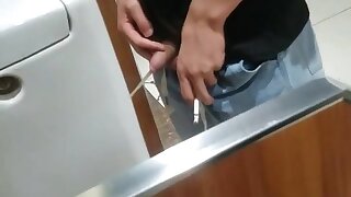 A male is pissing in the toilet 3.
