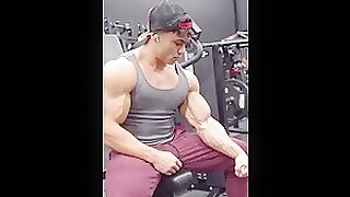 lean bodybuilder massages his biceps