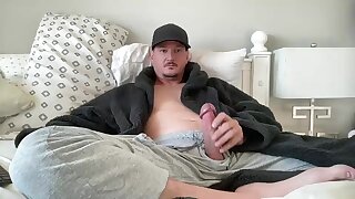 He jerks off his hard dick through his sweatpants